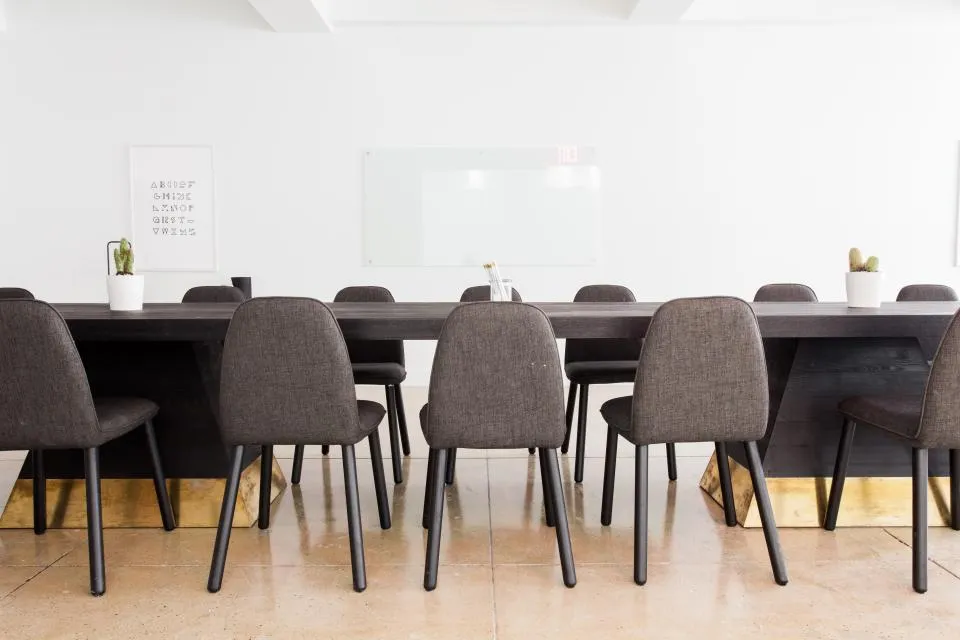 Sala de reuniones con mesa y sillas (imagen referencial)